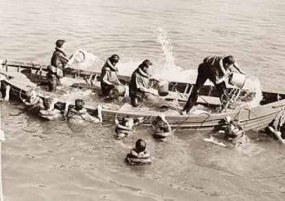 People bailing water out of a boat